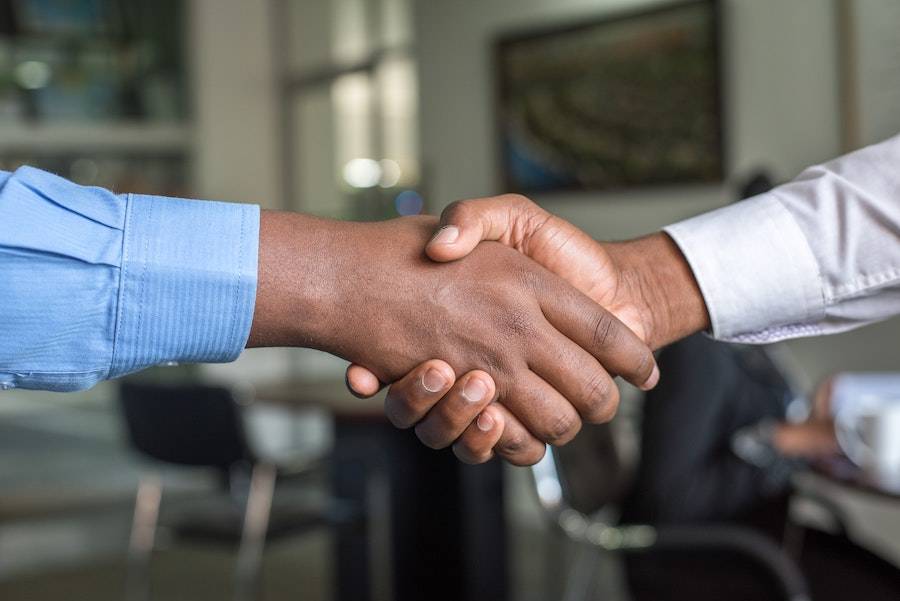 Two business people shake hands to show partnership between staffing agencies